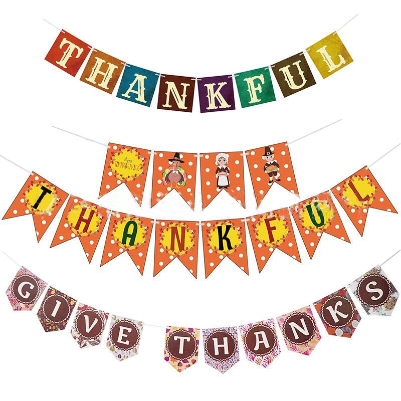 Thanksgiving Day Flag banner set in colorful paper card, with autumn motifs and “THANKFUL” and “GIVE THANKS” lettering.